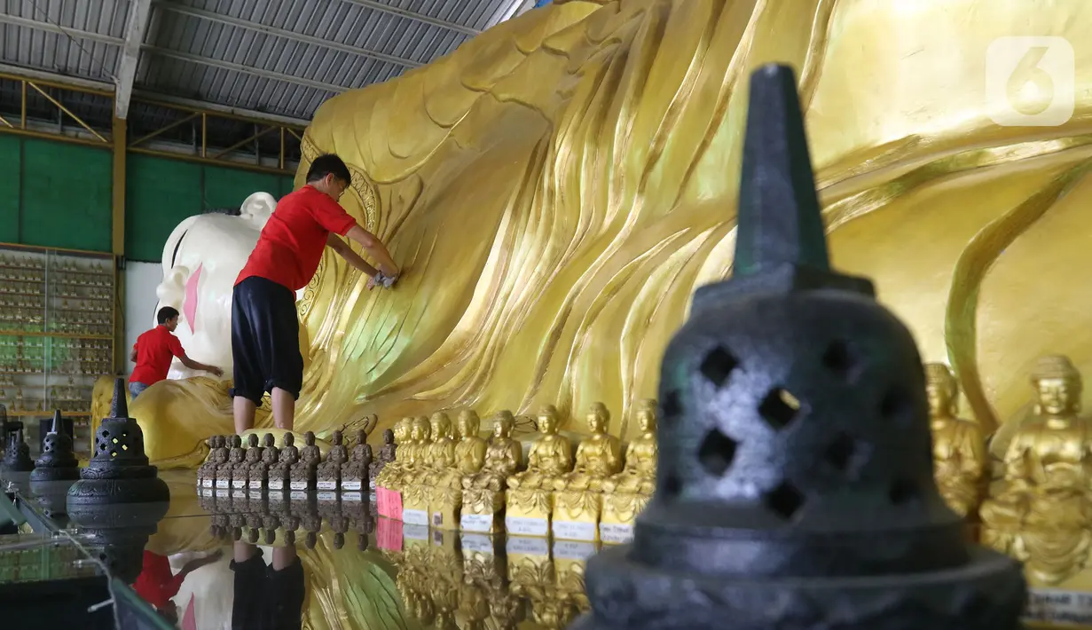 Pekerja membersihkan patung Buddha Tidur di Vihara Buddha Dharma dan 8 Pho Sat, Desa Tonjong, Tajurhalang, Bogor, Selasa (25/5/2021). Vihara itu mulai dihias dan dibersihkan untuk memberi kenyamanan bagi umat Budha yang akan beribadah saat peringatan Hari Raya Waisak. (Liputan6.com/Herman Zakharia)