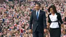 Presiden Amerika Serikat (AS) ke-44, Barack Obama menggandeng tangan sang istri, Michelle Obama, saat berjalan menuruni podium usai menyampaikan pidato di Hradcany Square, dekat Kastil Praha Republik Ceko, 5 April 2009. (AFP PHOTO / SAUL LOEB)