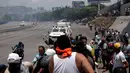 Pengunjuk rasa pendukung oposisi, Luis Alejandro berusaha menghindar dari kendaraan taktis Garda Nasional Venezuela di luar pangkalan militer 'La Carlota' di Caracas, Venezuela (30/4/2019). Luis ditabrak oleh tentara yang menghalau aksi demonstrasi tersebut. (Reuters/Ueslei Marcelino)