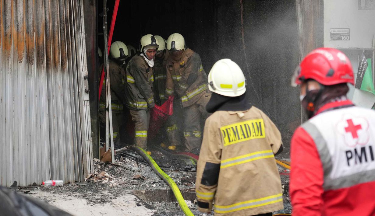 Penyebab kebakaran diduga berasal dari baterai yang terbakar di gudang lantai 1. Tampak dalam foto, personel dari Dinas Penanggulangan Kebakaran dan Penyelamatan mengevakuasi jenazah korban kebakaran di Jakarta, Selasa 9 Desember 2025. (AP Photo/Dita Alangkara)