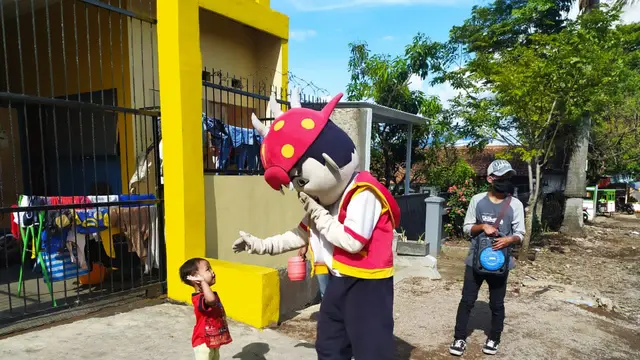 Salah seorang pengamen boneka tengah menyalami anak kecil di perkampungan warga Desa Jayaraga, Kecamatan Tarogong Kidul, Garut, Jawa Barat.