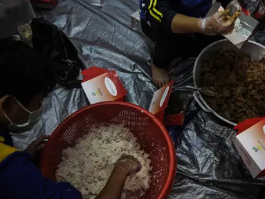 Petugas Taruna Siaga Bencana (Tagana) menyiapkan nasi kotak di Dapur Umum Kementerian Sosial Peduli Dampak Covid-19 di Kompleks Gedung Konvensi TMP Nasional-Utama, Kalibata, Jakarta, Rabu (8/4/2020). Dalam sehari, petugas menyiapkan 5.000 hingga 9.000 paket nasi bungkus. (Liputan6.com/Faizal Fanani)