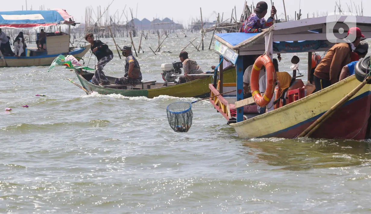 Sejumlah nelayan bersiap untuk melarung replika kapal berisi sesaji di Pantai Tarumajaya, Kabupaten Bekasi, Jawa Barat, Jumat (28/1/2022). Ritual dilakukan sebagai bentuk rasa syukur kepada Tuhan atas berlimpahnya hasil laut. (Liputan6.com/Herman Zakharia)