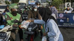 Aliansi Mahasiswa Lingkar Nusantara melakukan aksi dengan membagikan takjil di depan Gedung DPR/MPR, Jakarta, Rabu (6/4/2022). Dalam aksinya, mereka mendesak DPR untuk segera membentuk pansus terkait penambangan batu bara. (Liputan6.com/Johan Tallo)