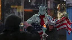 Seorang pria berpakaian seperti "Patung Liberty" foto bersama dengan warga saat salju mulai turun di Times Square di Manhattan borough New York, (22/1/2016). (REUTERS/Carlo Allegri)