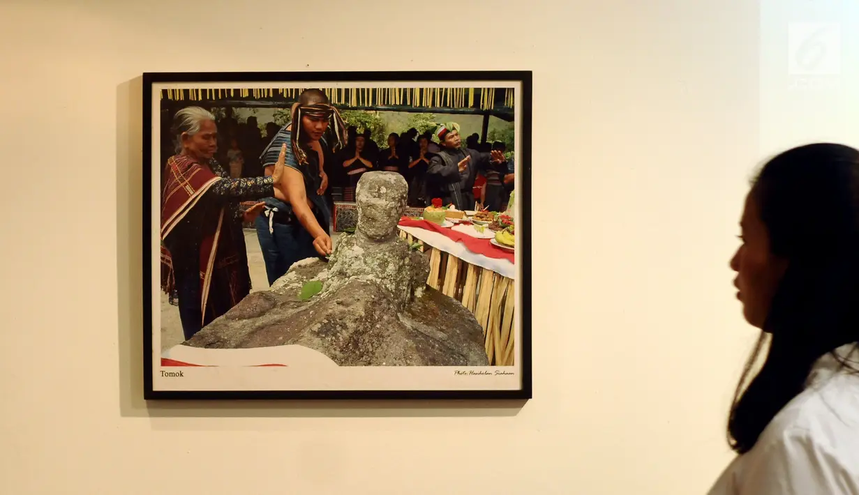 Pengunjung melihat foto yang dipamerkan saat Peluncuran Buku Danau Toba dan Mangongkal Holi di Jakarta, Kamis (24/8). Pameran foto menampilkan kehidupan masyarakat dan budaya Batak. (LIputan6.com/Helmi Fithriansyah)
