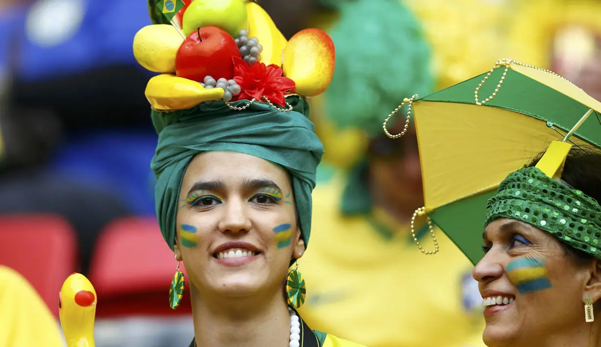 Menggunakan hiasan replika buah-buahan, salah satu suporter tim Samba menyaksikan langsung laga Brasil kontra Kamerun di Stadion Nasional Brasil, (23/6/2014). (REUTERS/Dominic Ebenbichler)