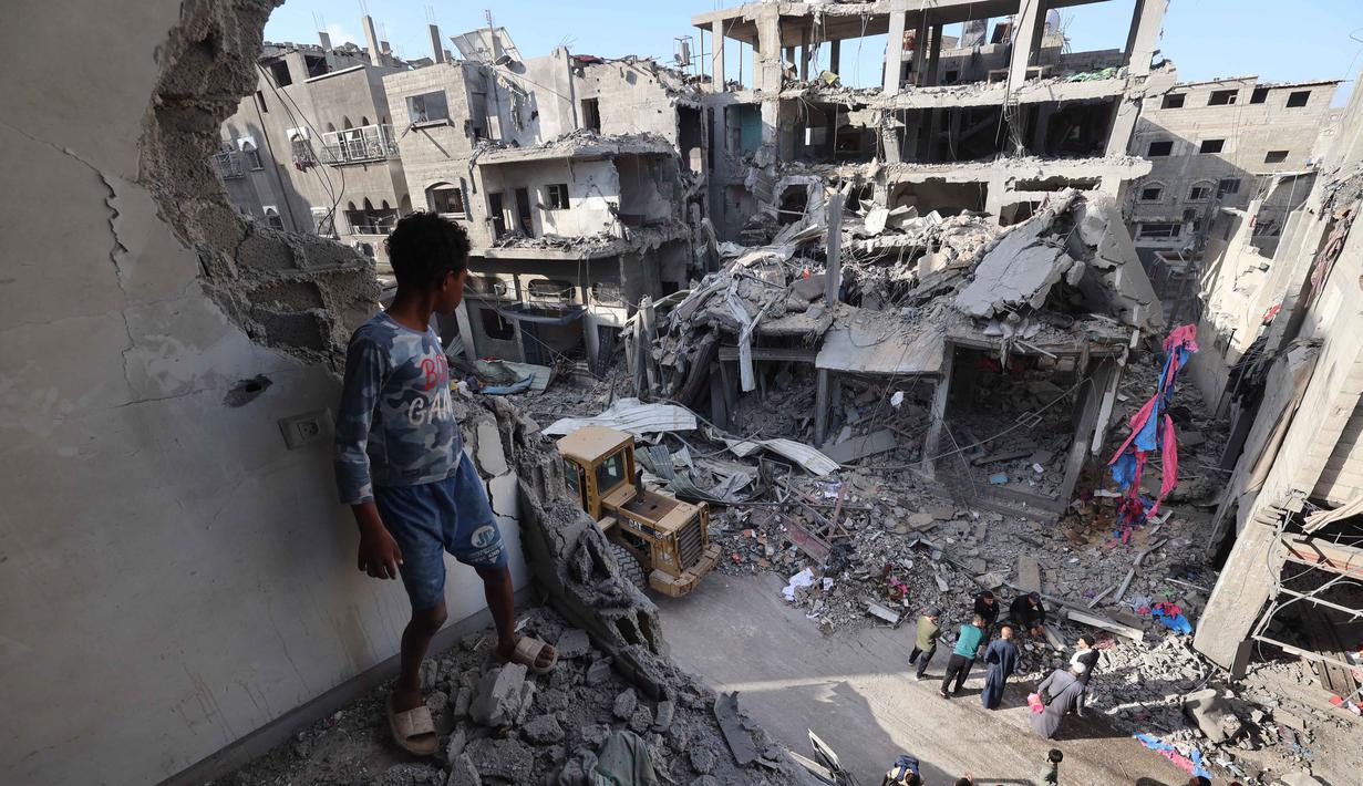 Seorang anak laki-laki Palestina yang mengungsi melihat bangunan yang rusak akibat serangan Israel di kamp pengungsi Maghazi, Jalur Gaza Tengah pada Kamis 21 Mei 2026. (Eyad Baba/AFP)