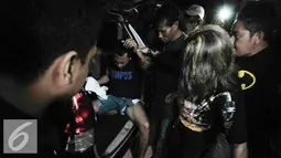 Petugas menurunkan Alfin Bernius Sinaga, supir perampokan disertai pembunuhan di Pulomas saat tiba di RS Polri, Kramatjati, Jakarta Timur, Kamis (29/12). (Liputan6.com/Yoppy Renato) 