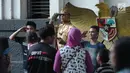 Warga berpose bersama manusia patung di pelataran Museum Fatahillah, Jakarta, Selasa (19/6). Kemudahan transportasi dan biaya yang murah menjadikan kawasan ini sebagai lokasi favorit warga untuk menghabiskan waktu libur. (Liputan6.com/Helmi Fithriansyah)