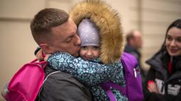 Nicolai (41) dari Ukraina mengucapkan selamat tinggal kepada putrinya Elina (4) di sebelah istrinya Lolita sebelum naik kereta menuju Polandia untuk melarikan diri dari perang di stasiun kereta di Lviv, Ukraina, 15 April 2022. Lebih dari 4,7 juta warga Ukraina mengungsi. (AP Photo/Emilio Morenatti)