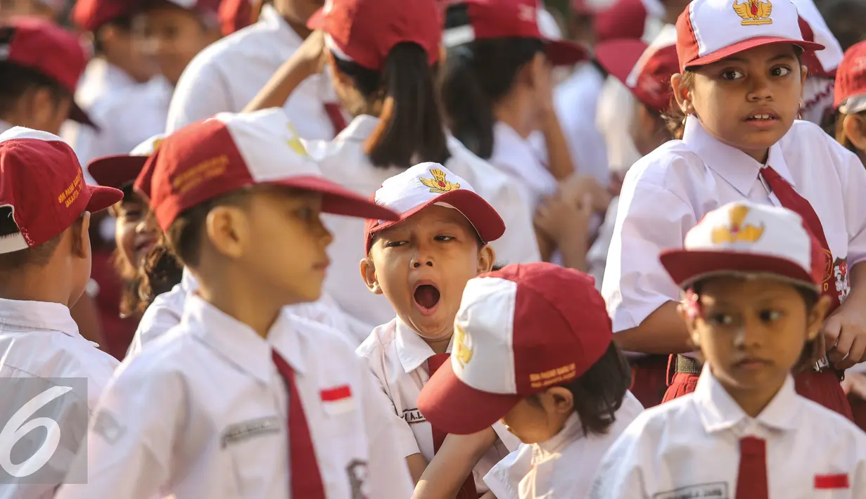 Seorang siswa menguap menahan kantuk sebelum upacara di SD Pasar Baru 05, Jakarta, Senin (27/7/2015). Usai libur panjang Idul Fitri para siswa kembali beraktivitas mengikuti pelajaran di sekolah untuk tahun ajaran 2015-2016. (Liputan6.com/Faizal Fanani)