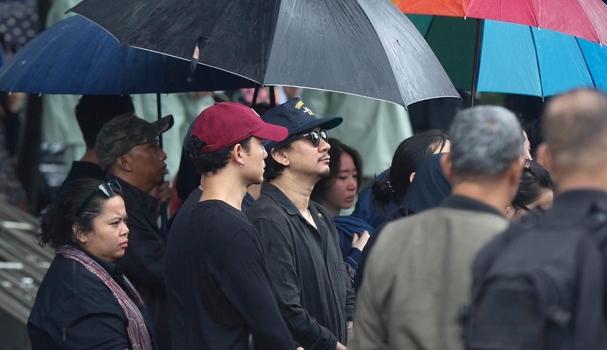 Vidi Aldiano meninggal dunia pada Sabtu 7 Maret 2026 setelah berjuang melawan kanker ginjal stadium tiga sejak 2019. Tampak dalam foto, musisi, presenter, sekaligus comedian, Vincent Ryan Rompies (tengah) saat menyaksikan prosesi pemakaman Oxavia Aldiano atau lebih dikenal dengan nama Vidi Aldiano di Tempat Pemakaman Umum (TPU) Tanah Kusir, Jakarta, Minggu (8/3/2026). (Kapanlagi.com/Budy Santoso)