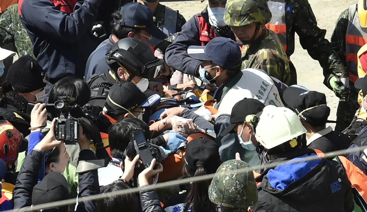 Lee Tsung-tien (42) diperiksa petugas medis setelah berhasil diangkat dari reruntuhan apartemen yang ambruk akibat gempa di Tainan, Taiwan, Senin (8/2). Dua korban berhasil diselamatkan setelah terperangkap selama lebih dari 50 jam. (AFP PHOTO/Sam Yeh)