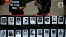 Anggota Jaringan Solidaritas Korban untuk Keadilan (JSKK) membawa foto para korban pelanggaran HAM saat melakukan Aksi Kamisan ke-795 di seberang Istana Merdeka, Jakarta, Kamis (16/11/2023). (Liputan6.com/Faizal Fanani)