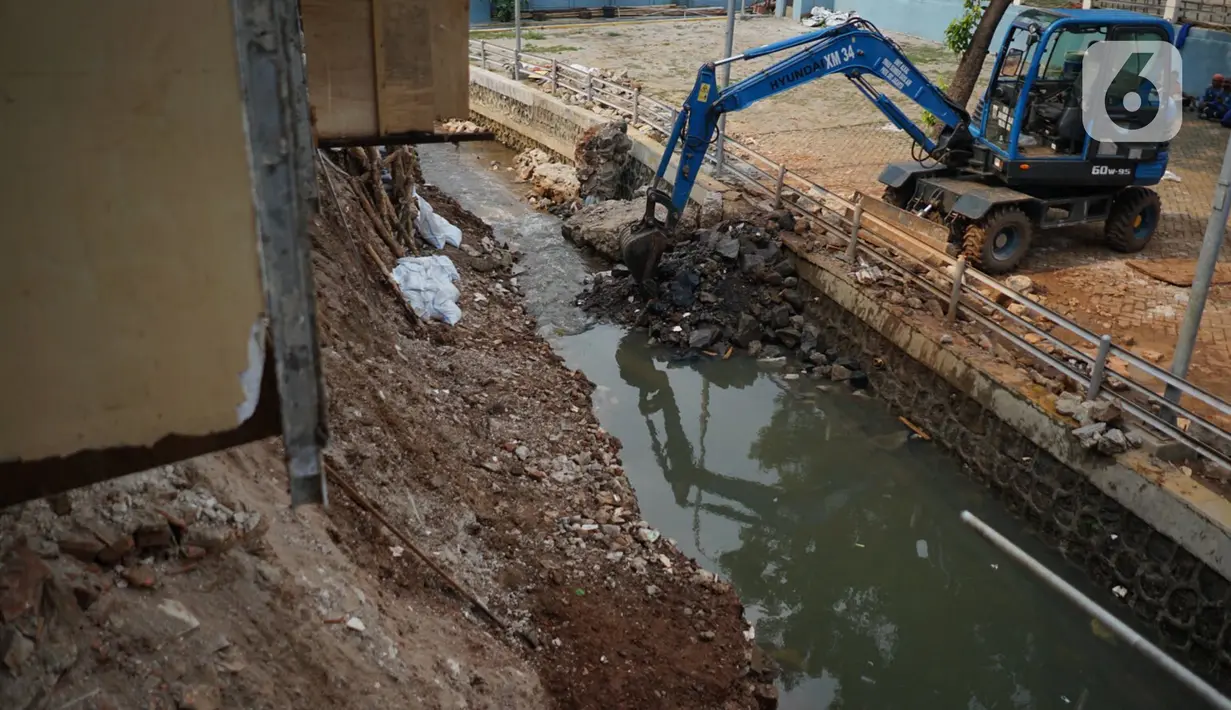 Alat berat mengeruk beton turap saluran air yang longsor di kawasan Jagakarsa, Jakarta, Kamis (17/9/2020). Selain karena hujan lebat, longsor diduga karena erosi tanah akibat pembuangan saluran air pencuci piring dan toilet dari warung makan di sekitar bantaran. (Liputan6.com/Immanuel Antonius)