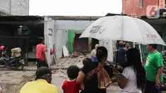 Warga melihat rumah yang dibongkar saat pembebasan lahan proyek Jalan Tol CIbitung-CIlincing seksi 4 di kawasan Semper Timur, Cilincing, Jakarta Utara, Selasa (8/11/2022). PT Cibitung Tanjung Priok Port Tollways (CTP Tollways) sebagai Badan Usaha Jalan Tol (BUJT) mencatat progres pembebasan lahan untuk seksi 4 sepanjang 7,28 km telah mencapai 100% dan ditargetkan pembangunannya selesai pada akhir tahun 2022. (Liputan6.com/Herman Zakharia)