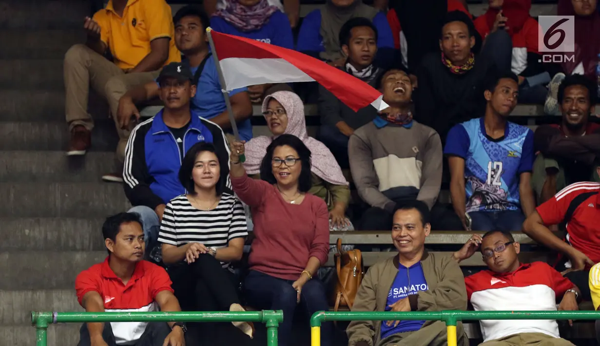 Suporter tim voli putra Indonesia mengibarkan bendera Merah Putih saat menyaksikan laga melawan Arab Saudi di Kejuaraan Voli Asia 2017 ke-16 di GOR Tri Dharma, Gresik, Senin (24/7). Indonesia unggul 3-1. (Liputan6.com/Helmi Fithriansyah)