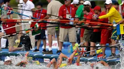 Para pelatih menyodorkan botol minuman kepada perenang yang sedang berlaga dalam lomba renang air terbuka nomor 10 km putra di Kejuaraan Renang Dunia di Yeosu, Korea Selatan, Selasa (16/7/2019). (AP Photo/Mark Schiefelbein)