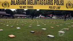 Sebanyak 2,1 ton ganja kering asal Aceh dalam kemasan diletakan saat rilis pengungkapan di Lapangan Bhayangkara, Jakarta, Senin (11/5/2015). Tampak petugas kepolisian berjaga di sekitar lokasi pengungkapan. (Liputan6.com/JohanTallo)