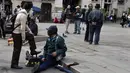 Tukang semir sepatu bertopeng melayani pelanggannya di kawasan La Paz, Bolivia (29/11). Dengan menutup wajahnya para tukang semir ini menyembunyikan identitas karena pekerjaan tersebut dipandang rendah oleh masyarakat lokal. (AFP PHOTO/Aizar Raldes)