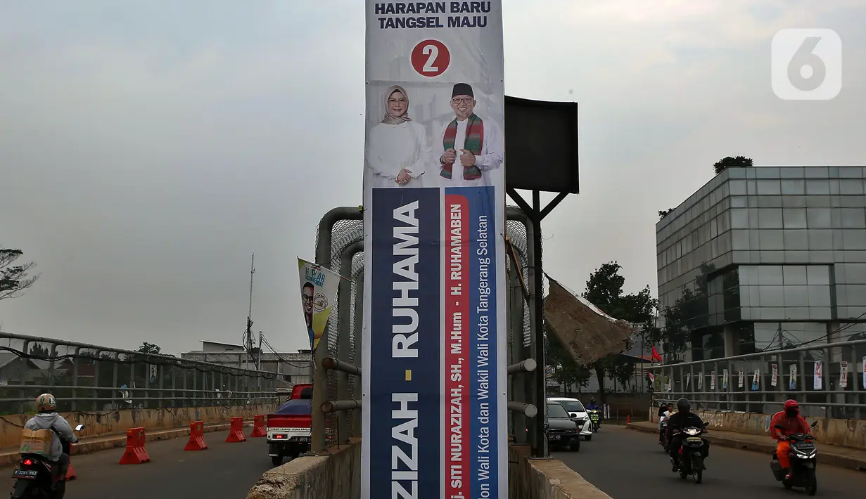 Kendaraan melintasi alat peraga kampanye (APK) yang terpasang di kawasan Depok, Jawa Barat dan Ciputat, Tangerang Selatan, Minggu (18/10/2020). KPU Kota Tangsel dan Depok membagikan sejumlah alat peraga kampanye kepada pasangan calon Pilkada 2020 serentak. (Liputan6.com/Johan Tallo)