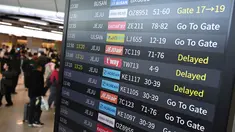Penumpang berjalan melewati papan informasi yang menampilkan penerbangan tertunda di Bandara Gimpo, Seoul, pada Kamis 13 November 2025, pada hari ujian masuk perguruan tinggi tahunan yang dikenal secara lokal sebagai Suneung. (Jung Yeon-je/AFP)