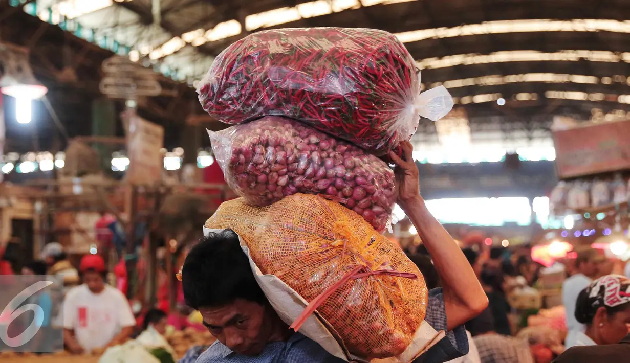 Pekerja membawa bawang merah di Pasar Kramatjati, Jakarta, Selasa (8/3). Harga bawang merah mengalami kenaikan hingga 40 persen. kenaikan harga hingga Rp 45 ribu per kg yang sebelumnya seharga Rp30 ribu per kg. (Liputan6.com/Angga Yuniar)