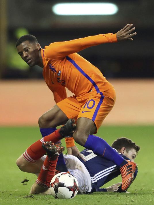 Pemain Belanda, Georginio Wijnaldum (atas) merebut bola dari pemain Skotlandia, Andrew Robertson pada laga persahabatan di Pittodrie, Aberdeen, Skotlandia (9/11/2017). Belanda menang 1-0. (Andrew Milligan/PA via AP)