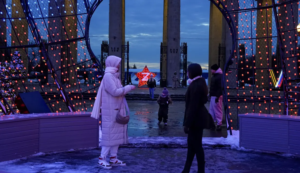 Orang-orang berjalan di dekat pintu masuk Taman Gorky yang dihias untuk perayaan Tahun Baru dan Natal di Moskow, Rusia, Selasa (20/12/2022). Sebelumnya Kyiv sempat memberi seruan pada Rusia untuk menarik pasukannya sebelum Natal, namun ditolak. (AP Photo/Alexander Zemlianichenko)