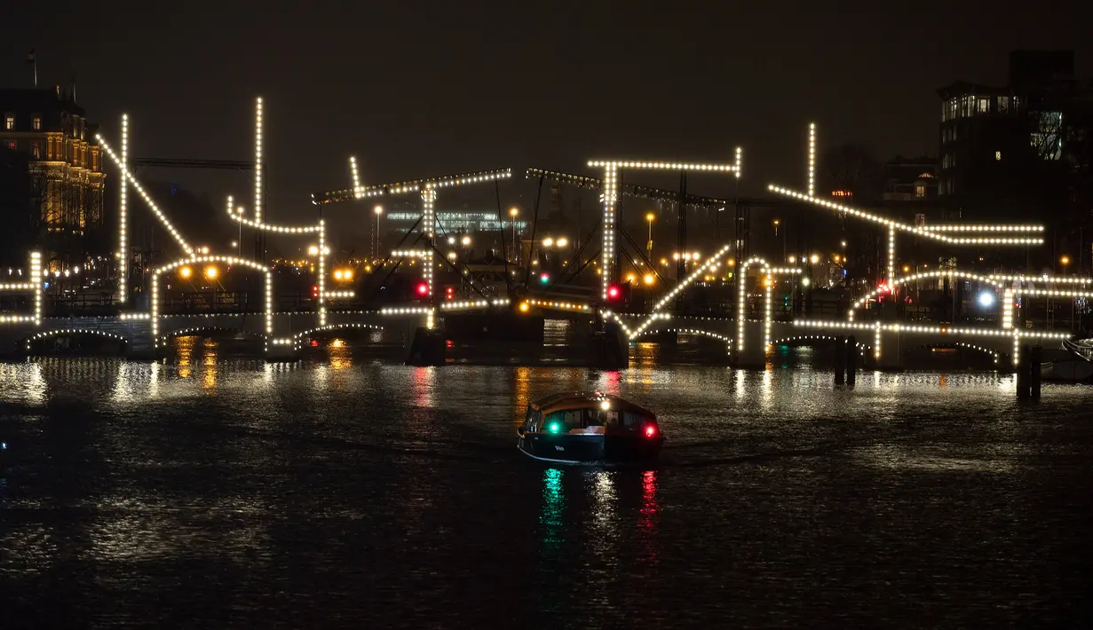 Karya seni berjudul "Nacht Tekening" atau Night Drawing oleh Krijn de Koning menghiasi Jembatan Skinny Amsterdam selama Amsterdam Light Festival di ibu kota Belanda, 27 November 2019. Festival dengan tema "DISRUPT!" ini digelar mulai 28 November hingga 19 Januari 2020 mendatang. (AP/Peter Dejong)