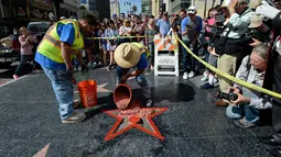 Pekerja memperbaiki Hollywood Walk of Fame milik Donald Trump usai dirusak seorang pria bernama James Lambert Otis , California, AS (26/10). Peristiwa tersebut diketahui terjadi sekitar pukul 5:45 pagi waktu setempat. (David McNew/Getty Images/AFP)