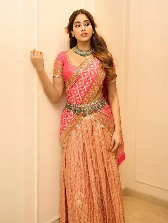 Janhvi Kapoor mengenakan sari tradisional warna pink keemasan. Dengan belt rumbai khas perempuan India. [@janhvikapoor]