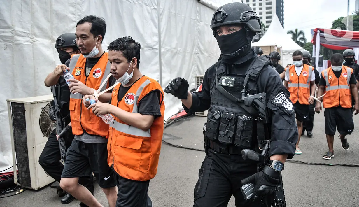 Polisi menggiring tersangka saat rilis kasus narkoba jaringan Timur Tengah di Mapolda Metro Jaya, Jakarta, Senin (14/6/2021). Satgas Narkoba Polda Metro Jaya bersama Polres Jakarta Pusat mengamankan tujuh tersangka dalam kasus ini. (merdeka.com/Iqbal S. Nugroho)