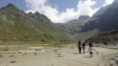 Pendaki berjalan di atas hamparan kering danau buatan Gabiet dekat Gressoney-La-Trinite di Lembah Aosta, Italia utara, Selasa (19/7/2022). Kekeringan parah masih melanda bagian utara negara itu. (AP Photo/Luca Bruno)