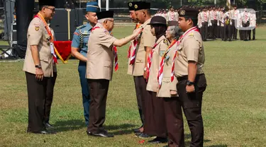 Wakil Presiden Ma`ruf Amin (tengah) didampingi Ketua Kwartir Nasional (Kwarnas) Pramuka Budi Waseso (kiri) menyematkan tanda penghargaan kepada anggota Pramuka di Bumi Perkemahan dan Graha Wisata (Buperta) Cibubur, Jakarta, Rabu (14/8/2024). (Liputan6.com/Herman Zakharia)