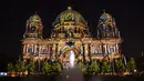 Katedral Berlin diterangi pada malam pembukaan resmi Festival Cahaya di Berlin, Jerman, Kamis (2/9/2021). Landmark dan bangunan paling terkenal di Berlin akan bersinar dan berkilau dengan berbagai warna dan jenis cahaya serta proyeksi dan kembang api selama Festival Cahaya. (Paul Zinken/dpa via AP)