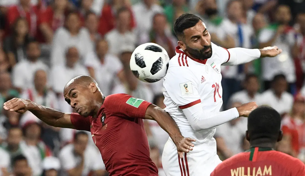 Duel pemain Portugal, Joao Mario (kiri) dan pemain Iran, Saman Ghoddos pada laga grup B Piala Dunia 2018 di Mordovia Arena, Saransk, Rusia, (25/6/2018). Portugal dan Iran bermain imbang 1-1. (AFP/Filippo Monteforte)