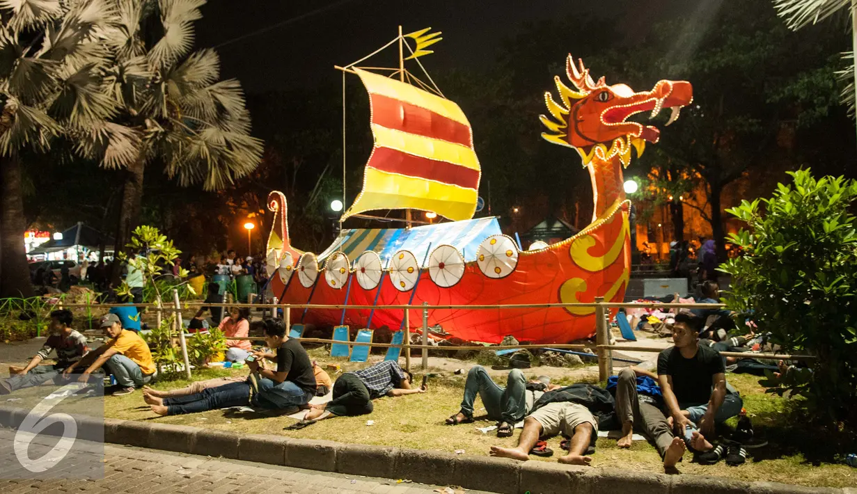 Sejumlah pengunjung yang terlihat kelelahan beristirahat di Pantai Lagoon , Ancol, Jakarta, Minggu (1/1). Usai menyaksikan berbagai macam hiburan di Ancol, mereka memilih istirahat di tempat tersebut. (Liputan6.com/Gempur M. Surya)