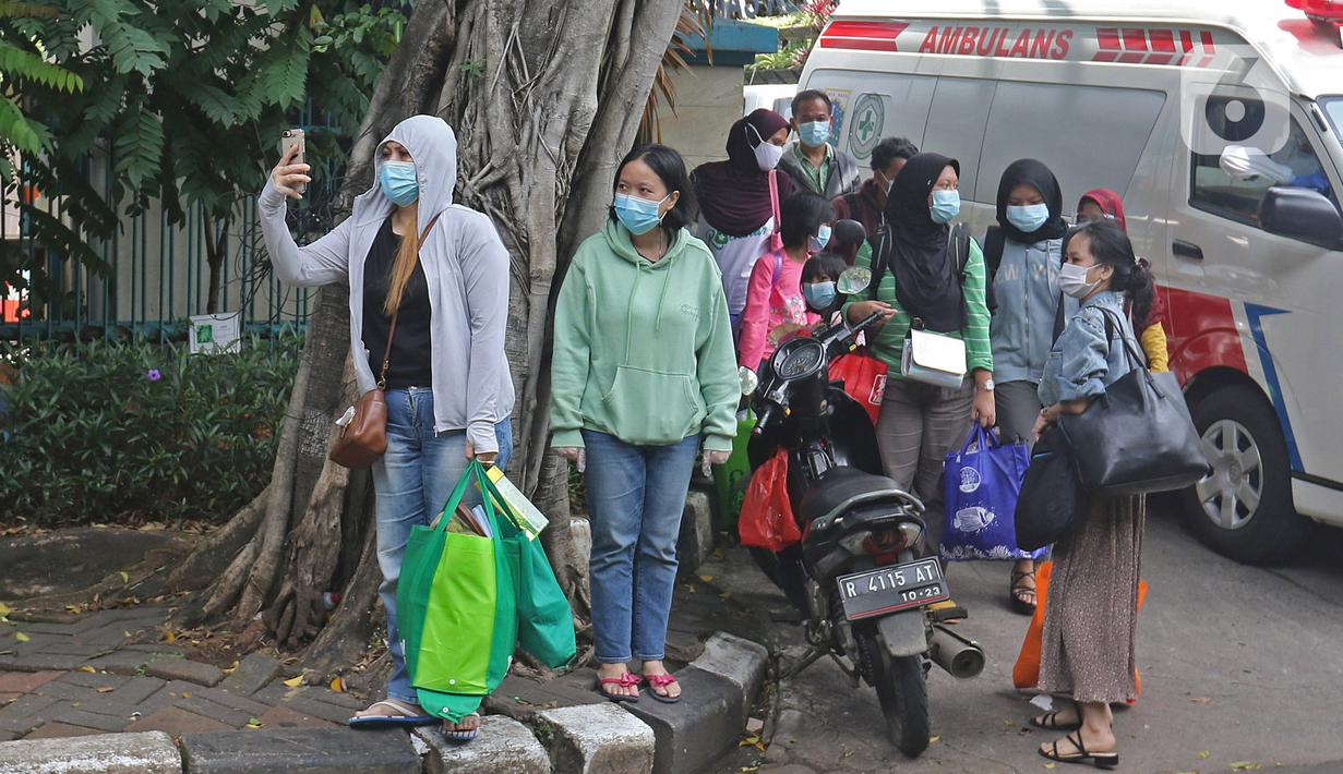 Sejumlah pasien Covid-19 Tanpa Gejala bersiap menaiki bus sekolah di Puskesmas Kecamatan Cilandak, Jakarta, Kamis (4/2/2021). Data Satgas Covid-19 per Kamis (4/2) mencatat kasus positif di Indonesia bertambah 11.434 orang. (Liputan6.com/Herman Zakharia)