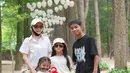 Kebersamaan Sarwendah dengan keluarganya di Korea Selatan. Ia mengenakan kemeja lengan pendek berwarna putih, celana panjang cokelat, topi putih, sunglasses, dan rahang yang masih digips hitam. [Foto: Instagram/sarwendah29]