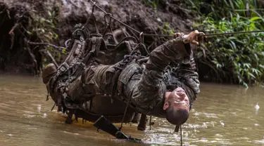 Tentara dari Combat Team Divisi Infanteri 1 Stryker Brigade Angkatan Darat AS melintasi sungai dengan tali dalam pelatihan perang hutan di Hawaii, 1 Maret 2017. Tentara melakukan kursus pelatihan hutan untuk fokus pada Asia dan Pasifik. (AP/Daniel Lin)