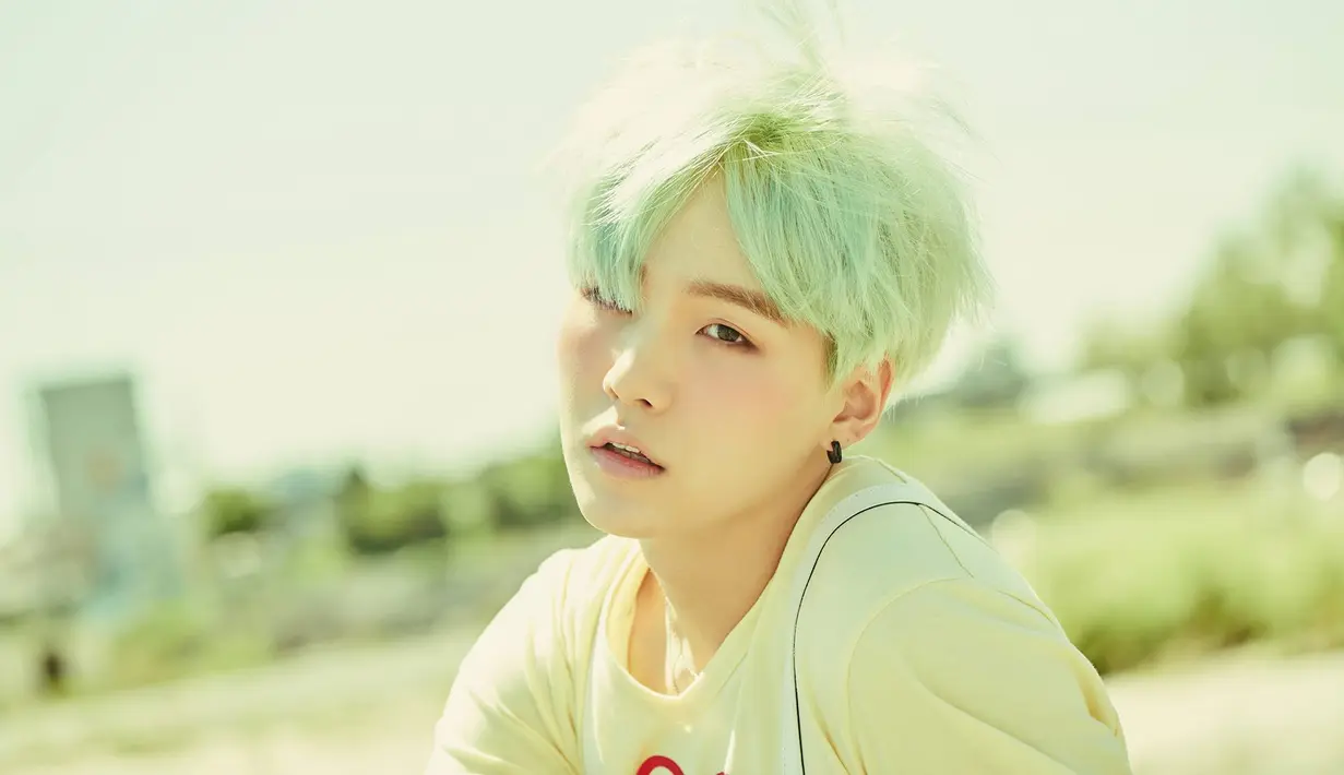 Suga BTS memang dikenal senang bereksperimen dengan rambutnya. Ia pernah mencoba mewarnai rambutnya dengan warna hijau. (Foto: Soompi.com)