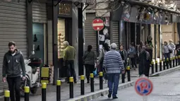 Orang-orang berjalan melewati toko-toko yang tutup atau setengah buka di kawasan Burj Hammoud, Beirut, Lebanon, 14 Desember 2021. Semarak jelang Natal yang biasa terjadi di Beirut, tak lagi terasa tahun ini karena krisis keuangan terburuk di Lebanon. (JOSEPH EID/AFP)