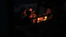 Sebuah keluarga Palestina menikmati makan sahur dengan penerangan lilin selama pemadaman listrik di kamp pengungsian Rafah, Jalur Gaza selatan, 11 Juni 2017. Selama ini Gaza menerima pasokan listrik Israel selama 3,5 jam setiap hari. (SAID KHATIB/AFP)