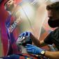Penjaga toko memasang masker berlogo Barcelona ke Manekin di Toko Asesoris Barcelona, Senin (25/5/2020). Di tengah pandemi virus Corona, Barcelona menjual masker dengan harga 18 euro atau sekitar Rp 291 ribu. (AFP/Lluis Gene)