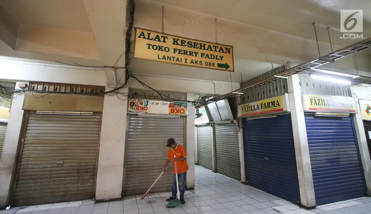 Petugas membersihkan Pasar Pramuka, Matraman, Jakarta Timur, Rabu (27/9). Hampir semua toko yang ada, menutup tempat usahanya lantaran harus mengajukan izin peralihan dari apotek rakyat ke apotek reguler. (Liputan6.com/Immanuel Antonius)