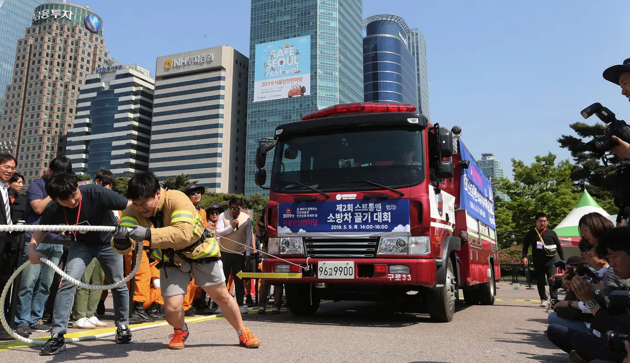 Petugas pemadam kebakaran Lim Sung-joo menarik sebuah truk pemadam kebakaran dengan seutas tali saat Safe Seoul Festival di Seoul, Korea Selatan, Kamis (9/5/2019). Festival ini mengampanyekan kesadaran keselamatan atas kebakaran, bencana alam hingga berlalu lintas. (AP Photo/Ahn Young-joon)