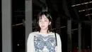 Kim Minha tampil dengan sweater putih motif kupu-kupu biru. Dipadukan celana denim dan sepatu putihnya. [Dior]