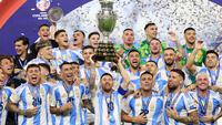 Pemain Argentina, Lionel Messi mengangkat trofi saat merayakan juara pada laga final Copa America 2024 di Hard Rock Stadium, Miami, Florida, Senin (15/07/2024) WIB. (AFP/Charly Triballeau)